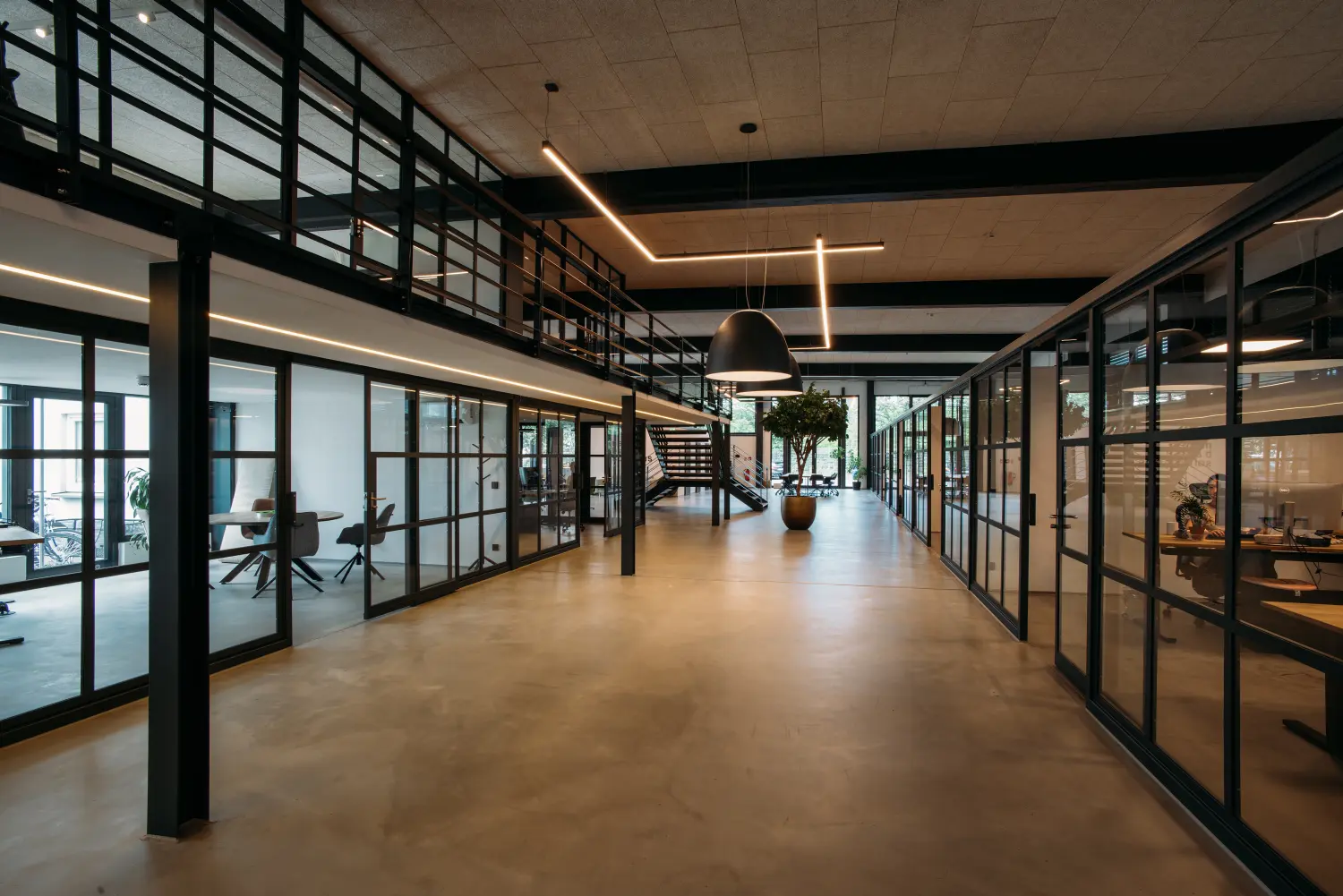 Modernes Büro mit offener Raumaufteilung, eleganten Glastrennwänden und Tageslicht. Ideal für geschäftsbezogene Themen.